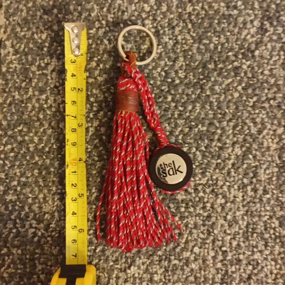 The Sak red and brown leather keychain the Sak emblem